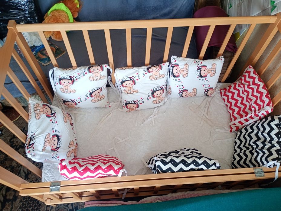 Ліжечко дитячє з подушками.