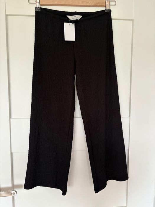 Czarne spodnie kreszowane H&M r.134