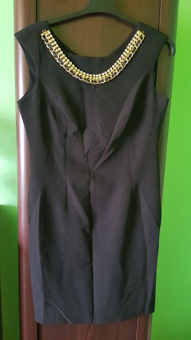 Piękna elegancka obcisła czarna sukienka z naszyjnikiem