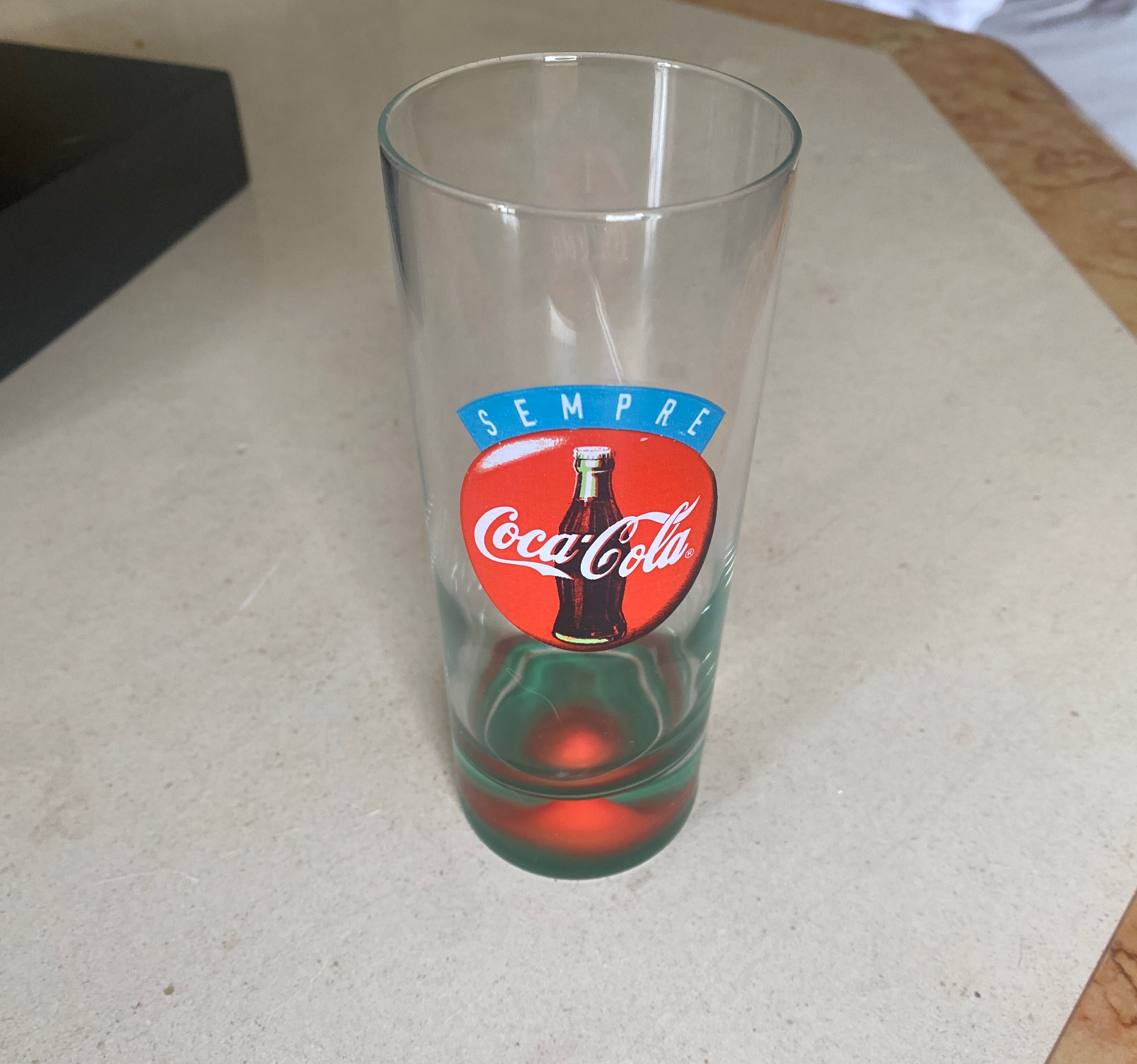 Copo antigo coca cola com relevo mama no fundo.