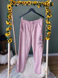 Różowe damskie spodnie na gumce z prosta nogawka oraz haftowanym kwiat
