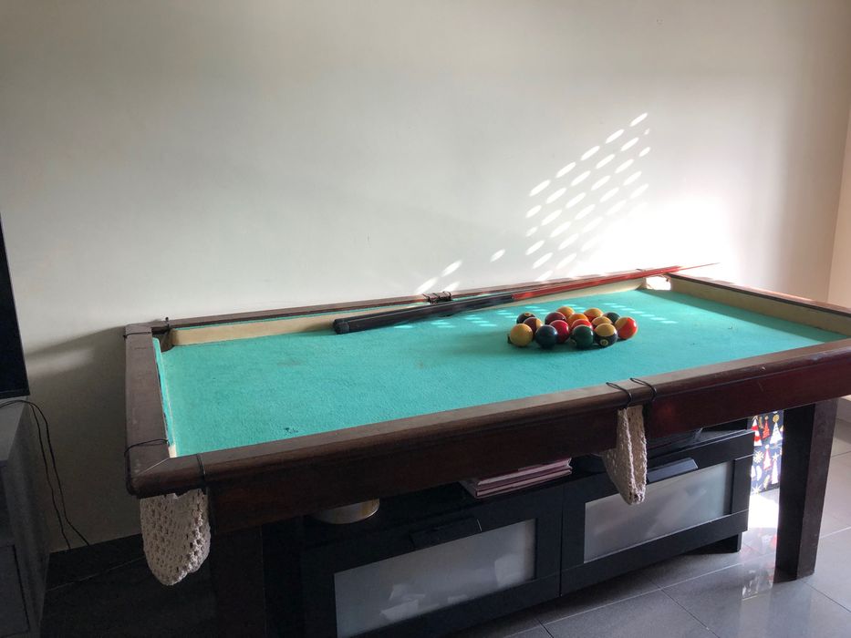 Mesa de bilhar com bolas e tacos