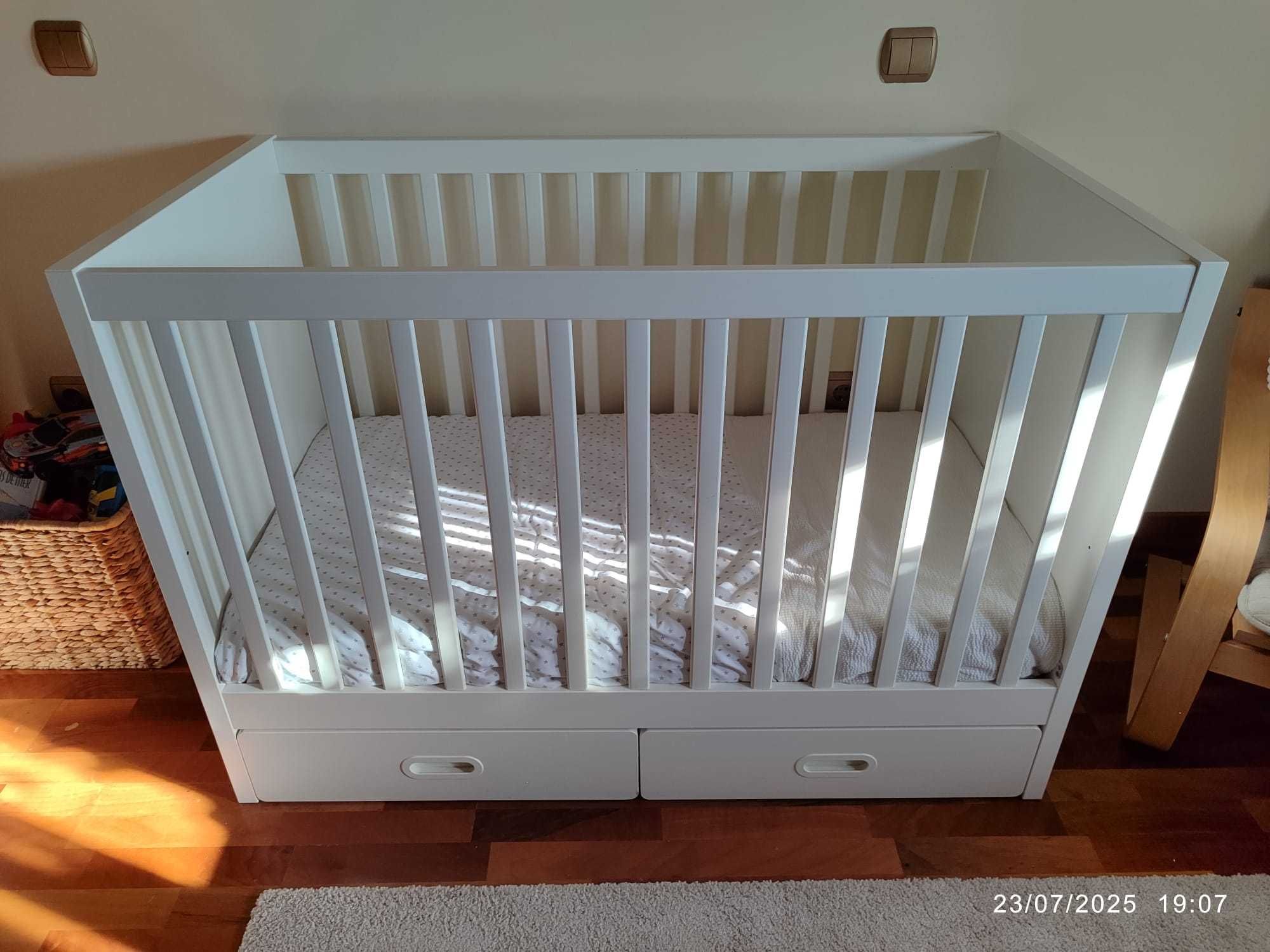 Cama de bebé com grades de proteção.