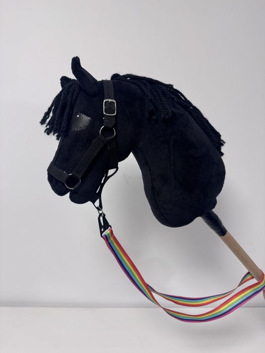 Piękny czarny hobby horse z kantarem i lonżą