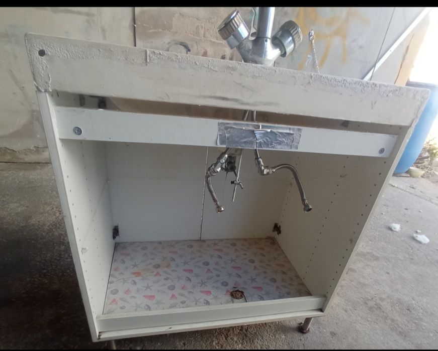 Móvel de casa de banho com lavatório e torneira vintage.
O móvel é azu
