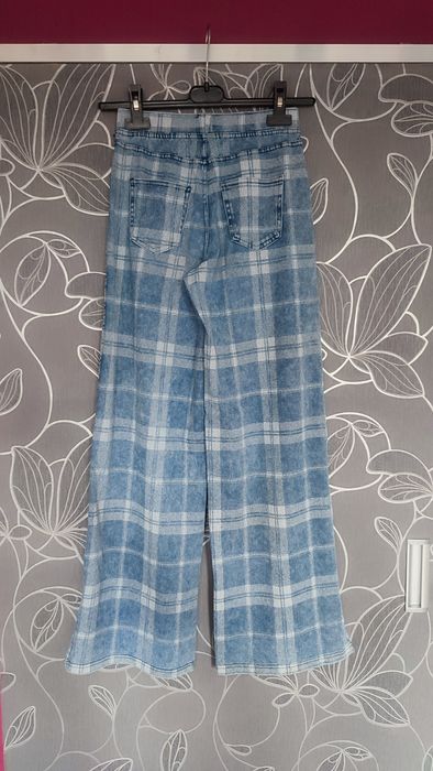 Spodnie w kratkę, rozszerzane i bluzka.