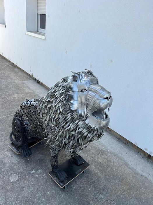Leão sentado em metal reciclado