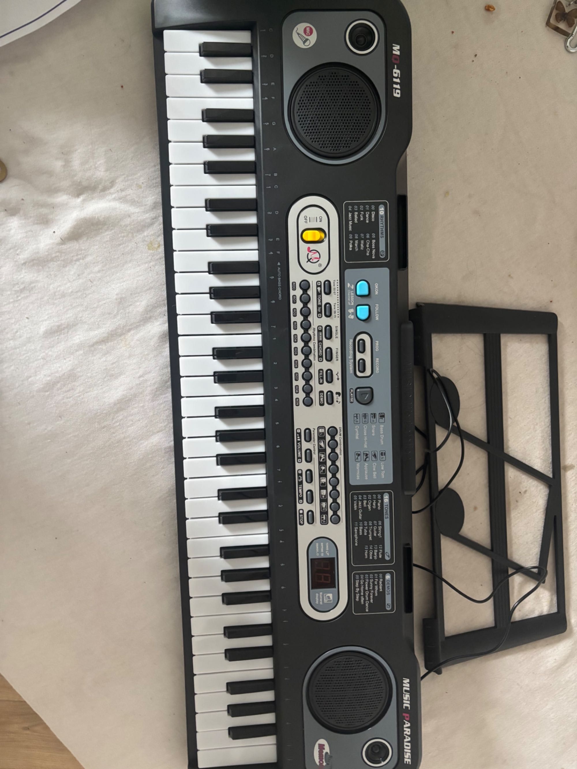 Keyboard z mikrofonem, ładowarką i instrukcją obsługi.