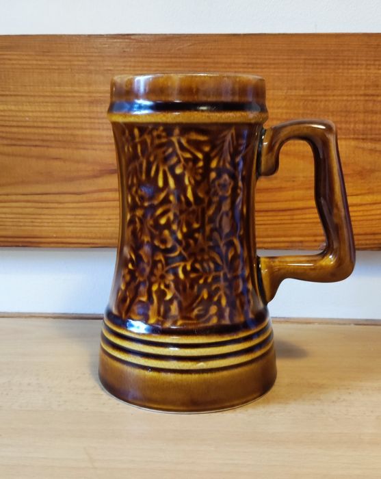 Kufel z zakladu ceramicznego w Mirkstowicach w roślinny deseń.