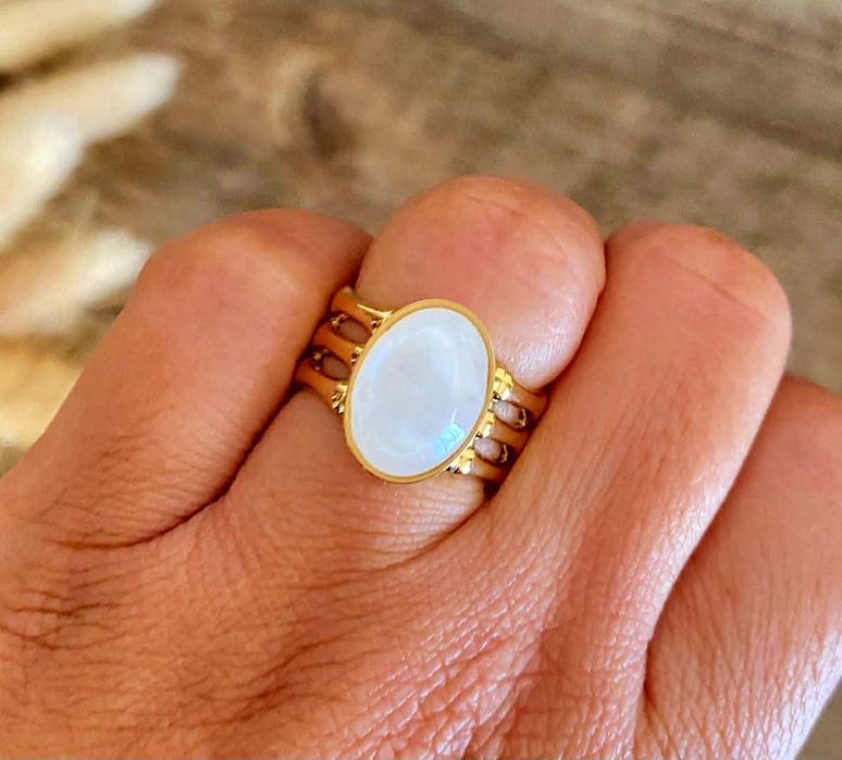 Anel dourado, em aço, com uma madrepérola oval.  Ajustável
