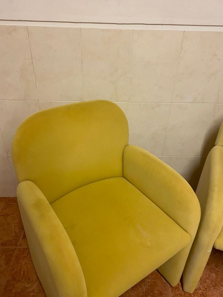 Sofás individuais em amarelo e bordo.