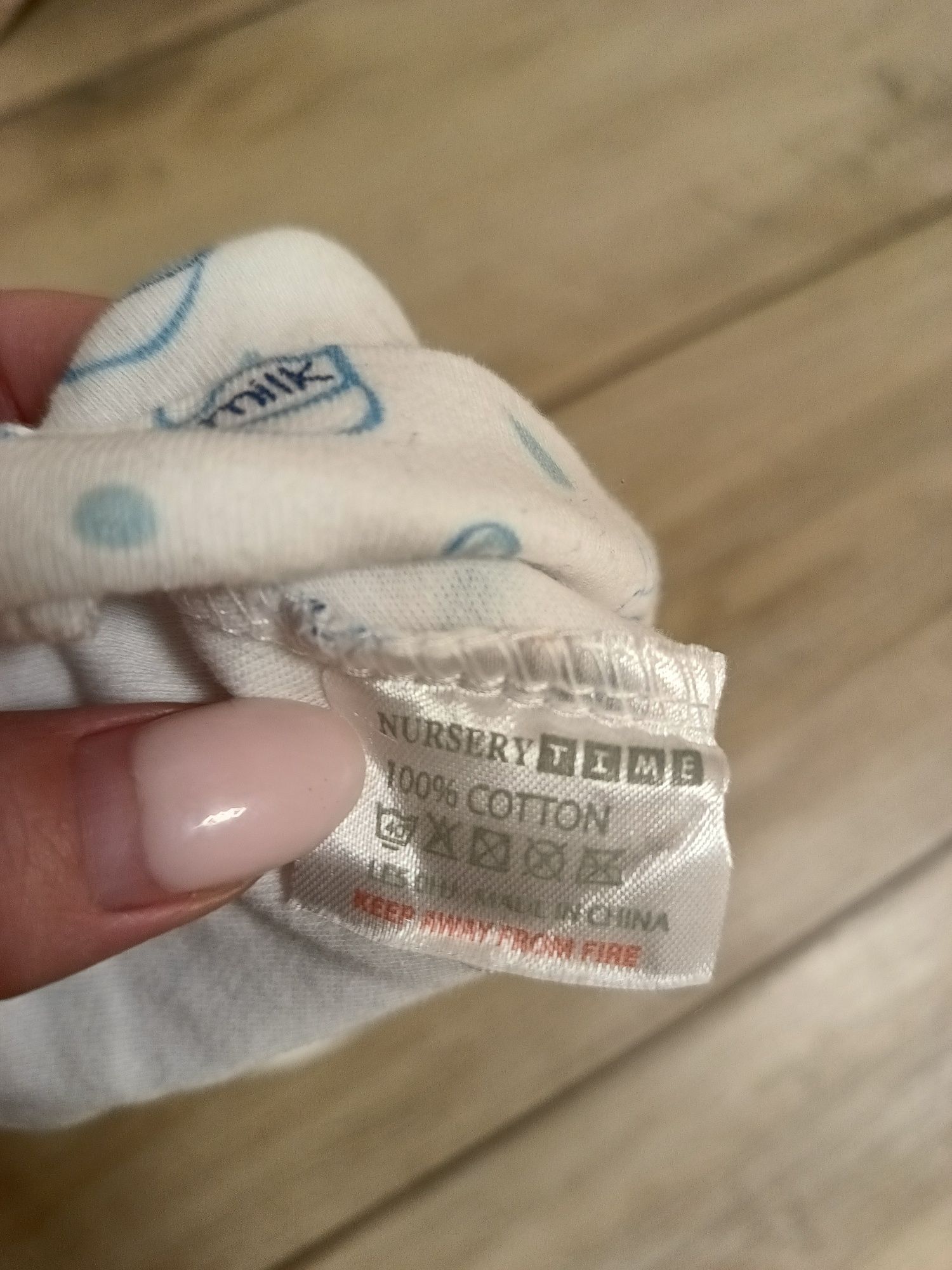 Biała dziecięca niemowlęca czapeczka w ozdobny wzór butelki mleka unis
