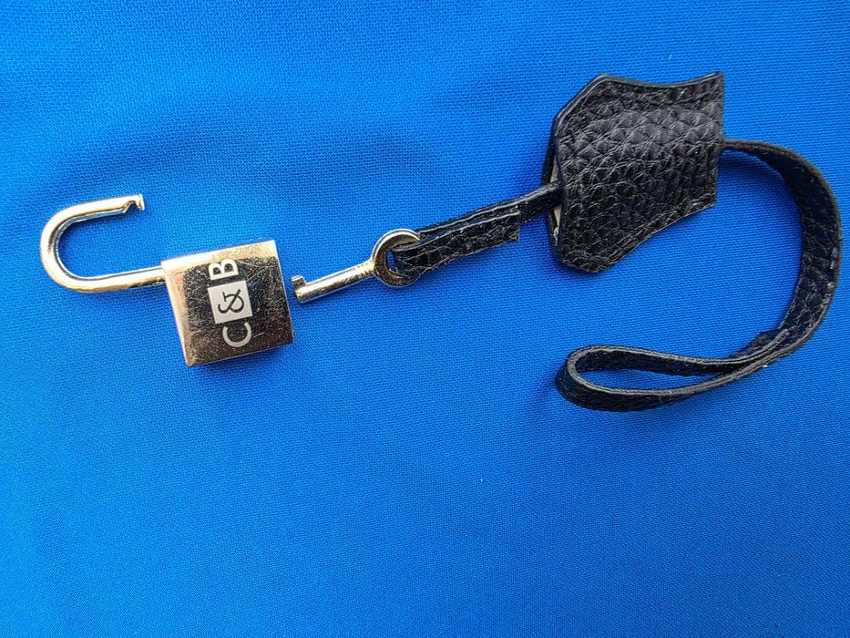 чорний шкіряний брелок з золотим замком та написом "C&B".
