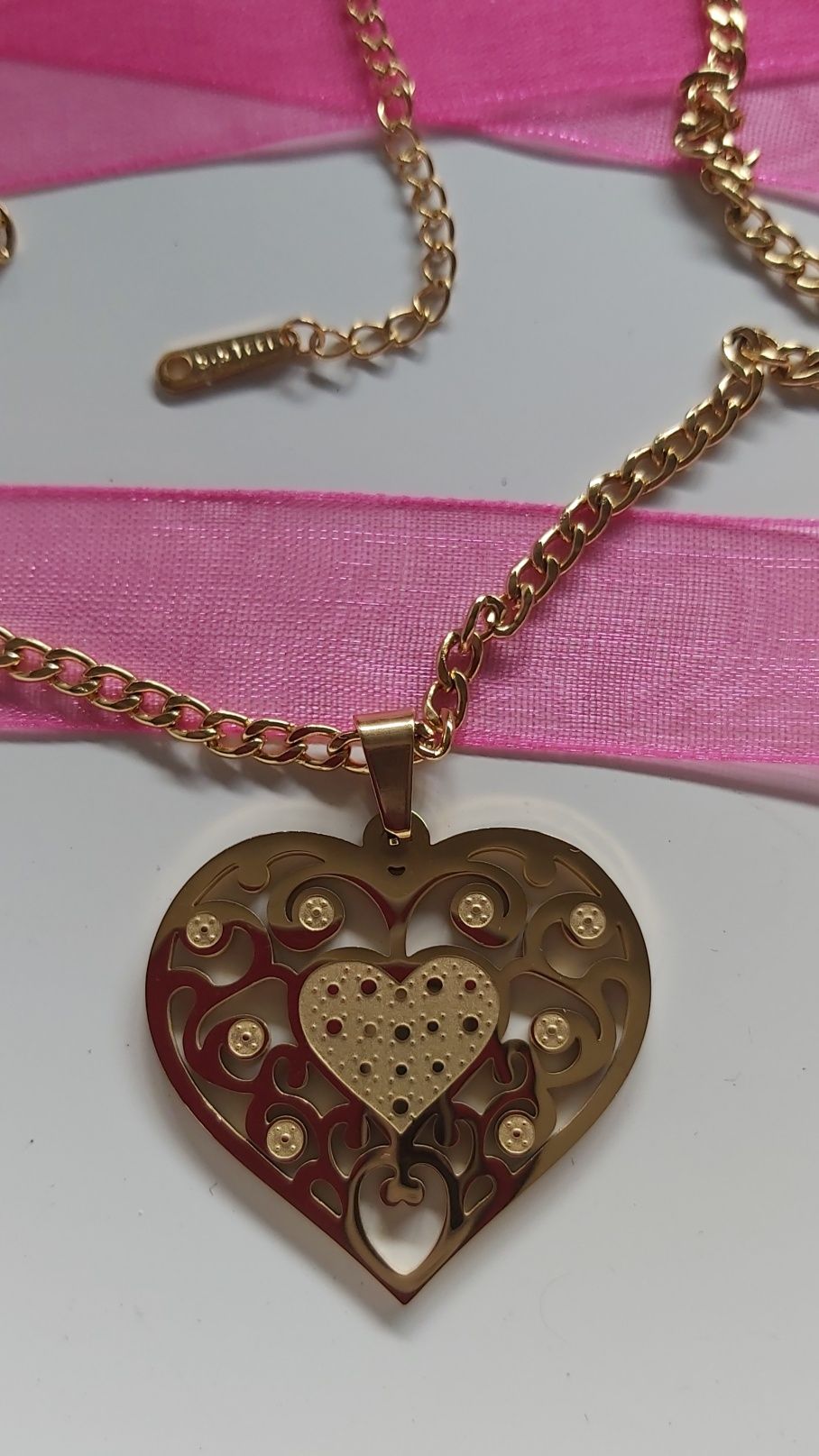 Colar dourado, em aço, com coração. Malha média. Com extensor