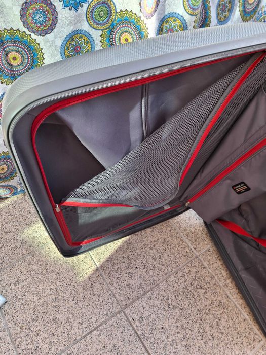 Mala de viagem cinzenta rígida com muito boa capacidade .