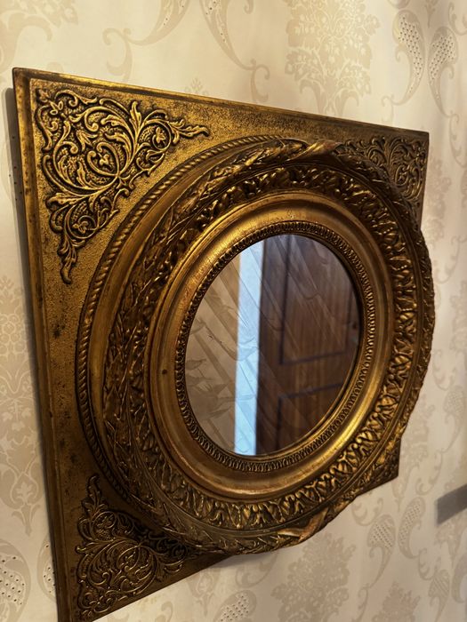 Espelho antigo em moldura de talha dourada.