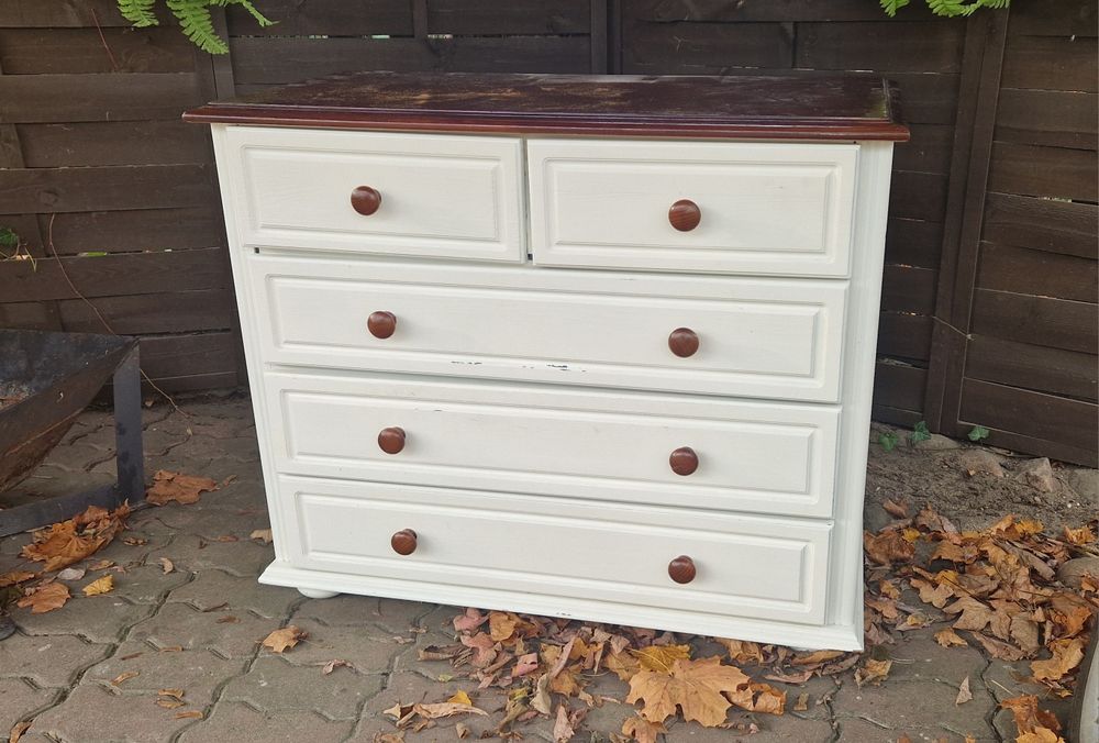 Komoda biała z brązowym blatem.