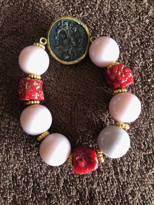 pulseira com bolas rosa e medalha muito bonita  com detalhes originais