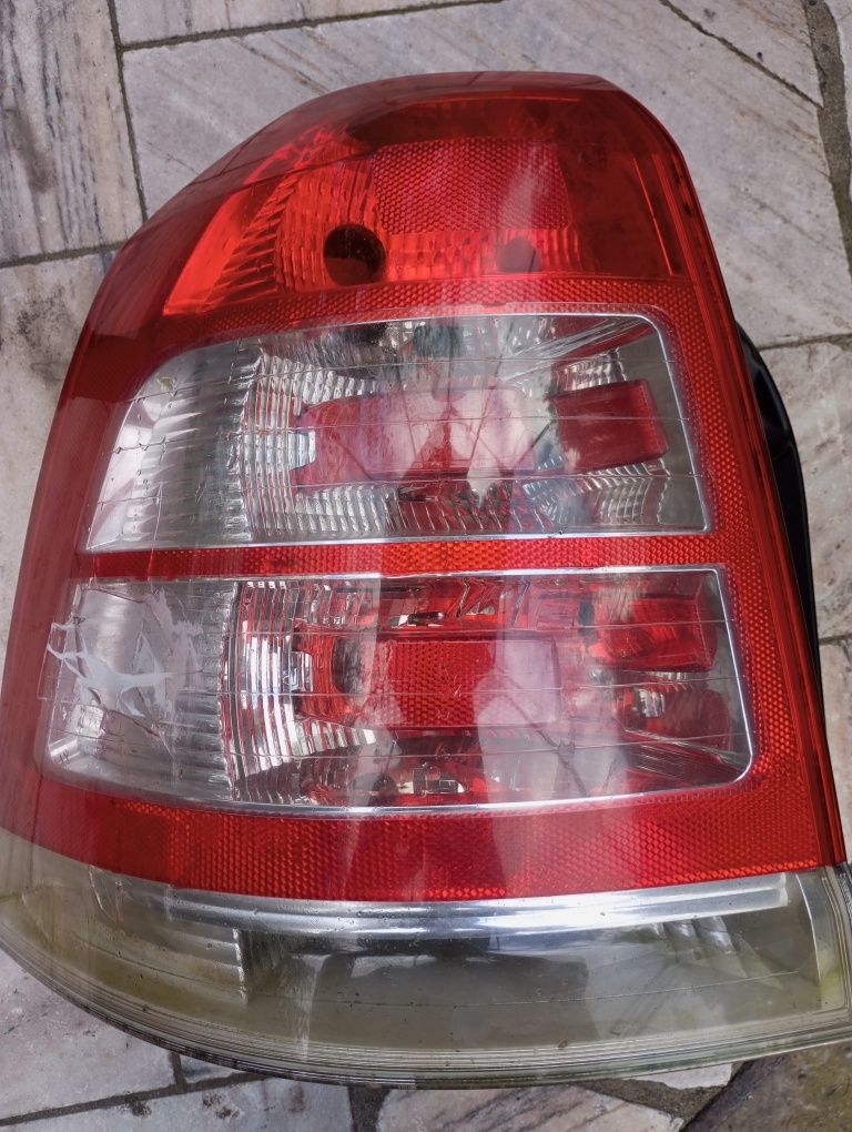 Lampa tylna Zafira B lewa z panelem posiada żarówki i nakrętki