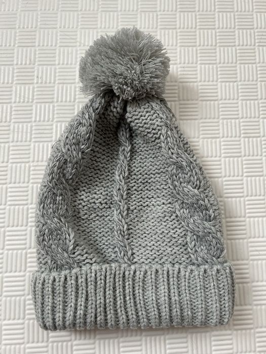 Вʼязана зимова жіноча шапка з помпоном сірого кольору