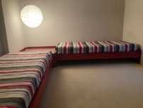 Conjunto de duas camas individuais e mesa de cabeceira