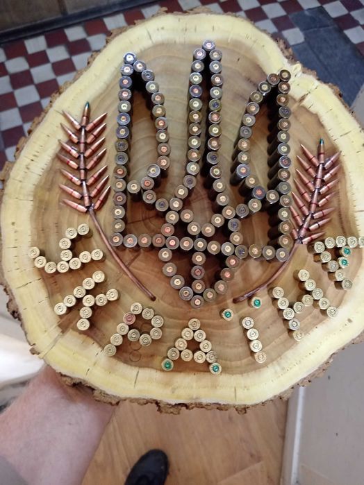 Герб України на зрізі дерева вибиті із стреляних гільз.