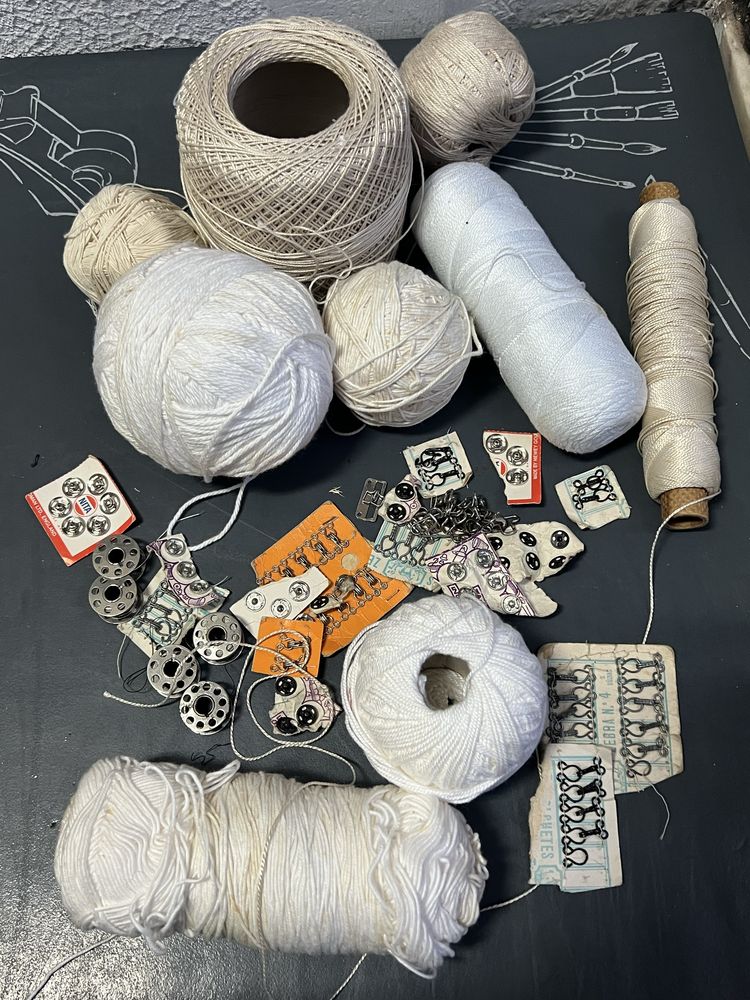 Retalhos de roupa nova, agulhas, novelos de lã e renda