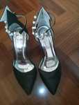 Sapatos em  preto com o pormenor de contas para fixar no tornoz