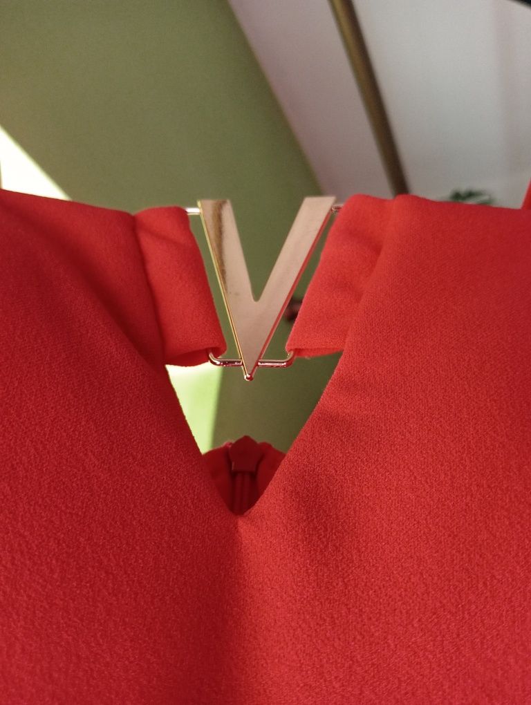 Czerwona sukienka, krótka, elegancka, złoty element w kształcie litery