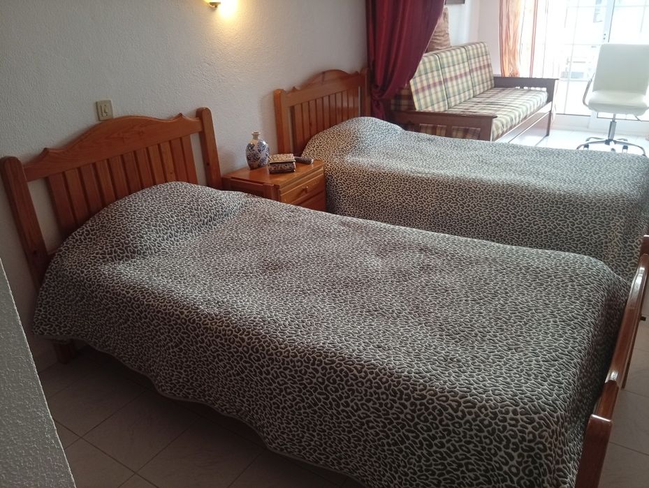 Duas camas de solteiro com uma mesa cabeceira