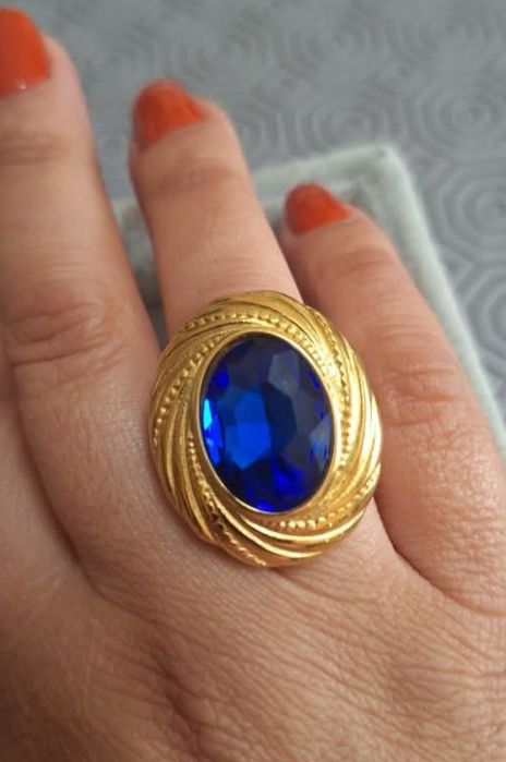 Anel dourado, em aço, com grande pedra oval azulão. T18