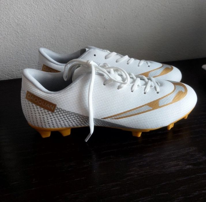 Chuteiras brancas e douradas