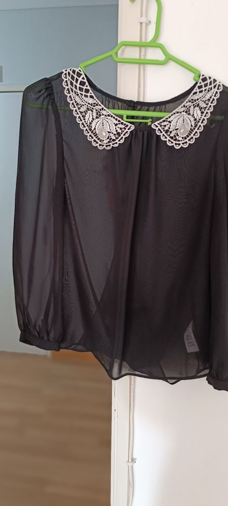 Camisa preta com gola bordada em branco. Aberta atrás. Tecido transpar