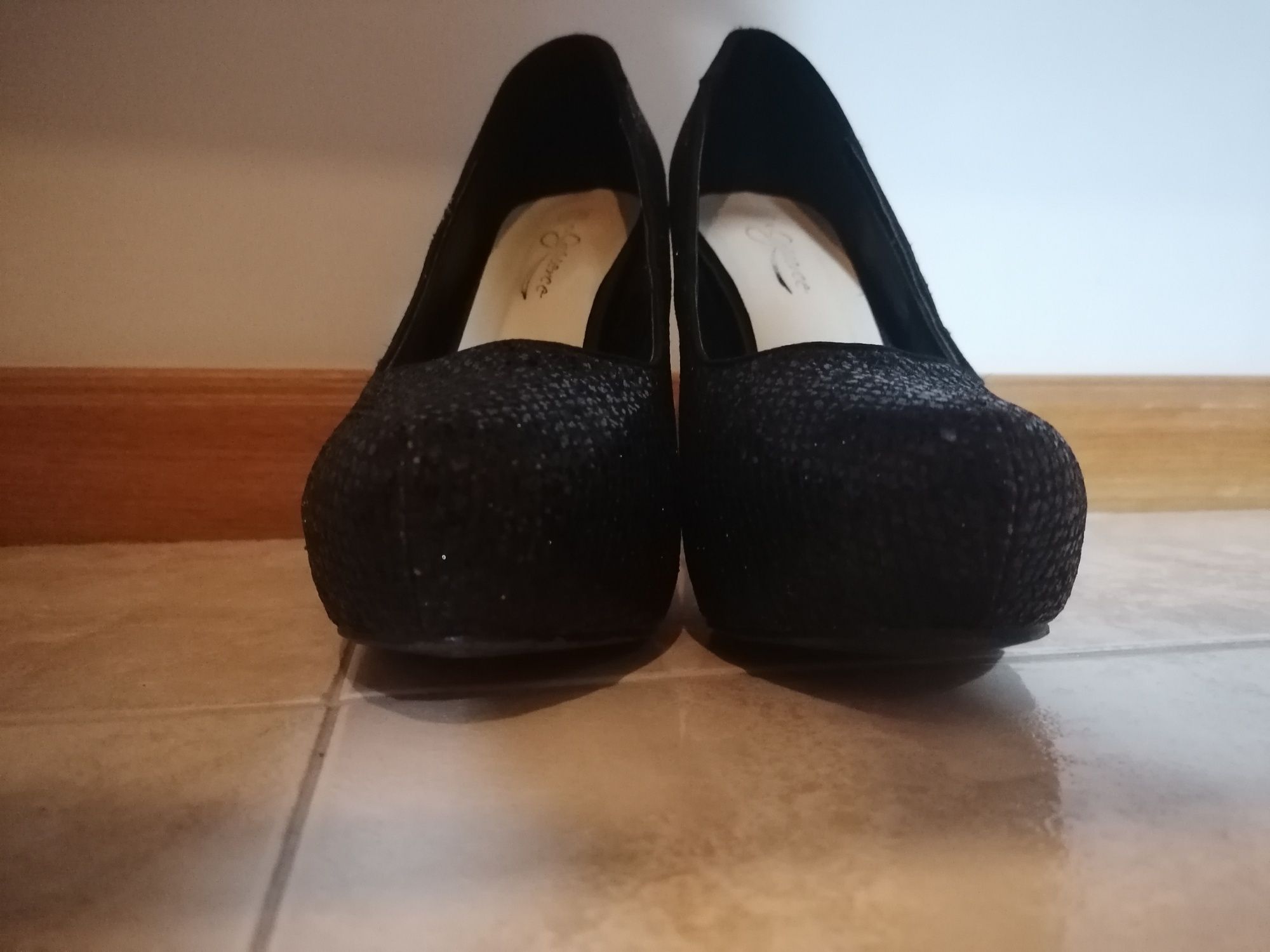 Sapatos pretos de Cunha a frente