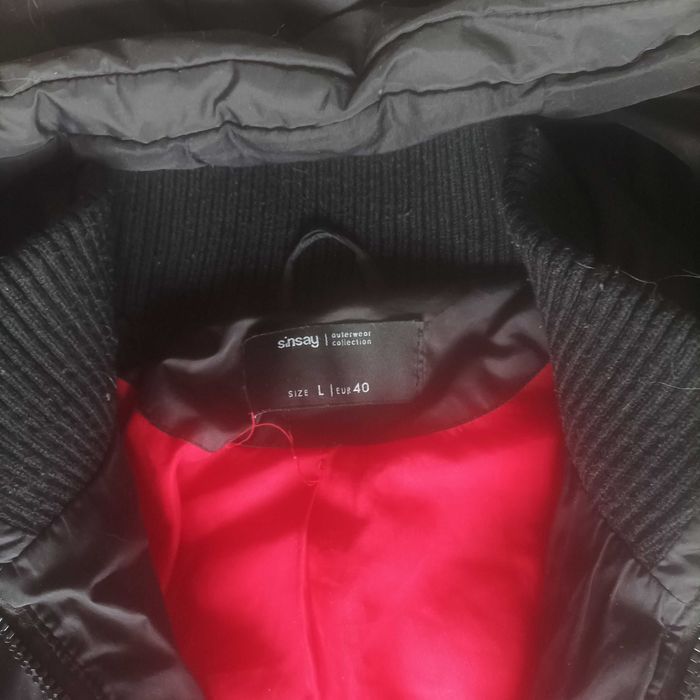 Czarny pikowany płaszcz damski Sinsay z czerwoną podszewką.L