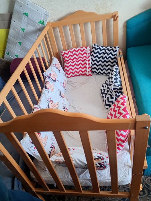 Ліжечко дитячє з подушками.