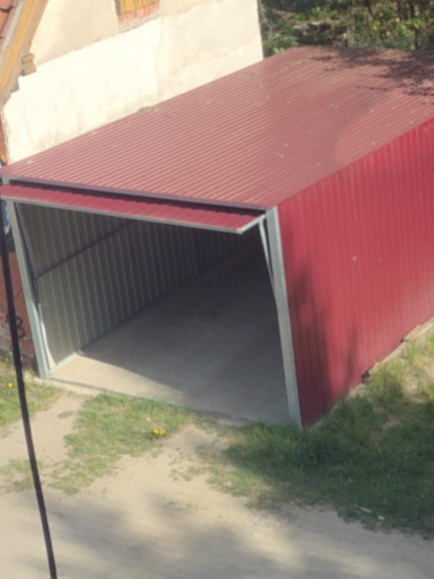 Garaż blaszany z podnoszoną bramą.