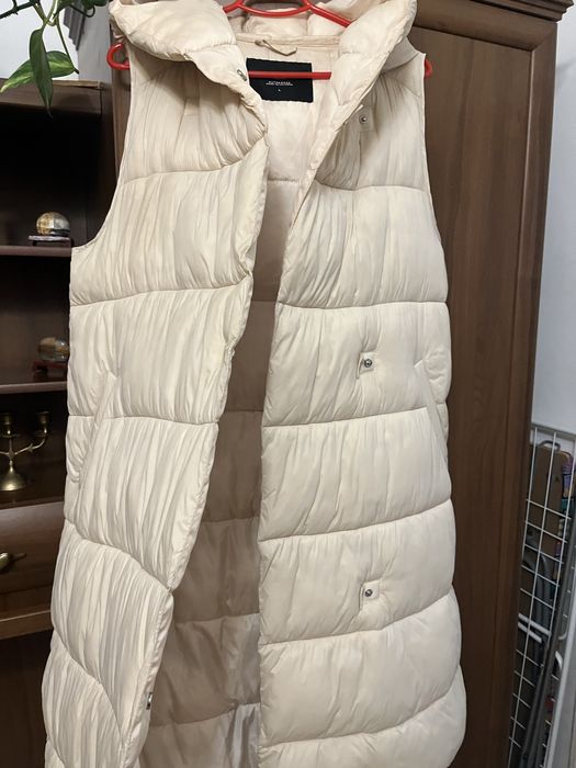 Безрукавка зимова, кремового кольору на закльопках