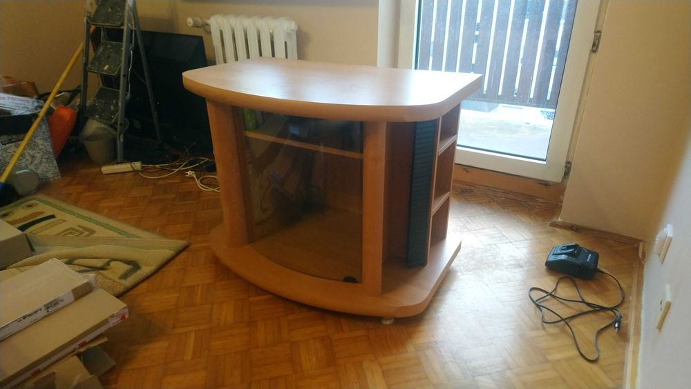 Szafka RTV do salonu w kolorze jasnego drewna ze szklaną witryną.