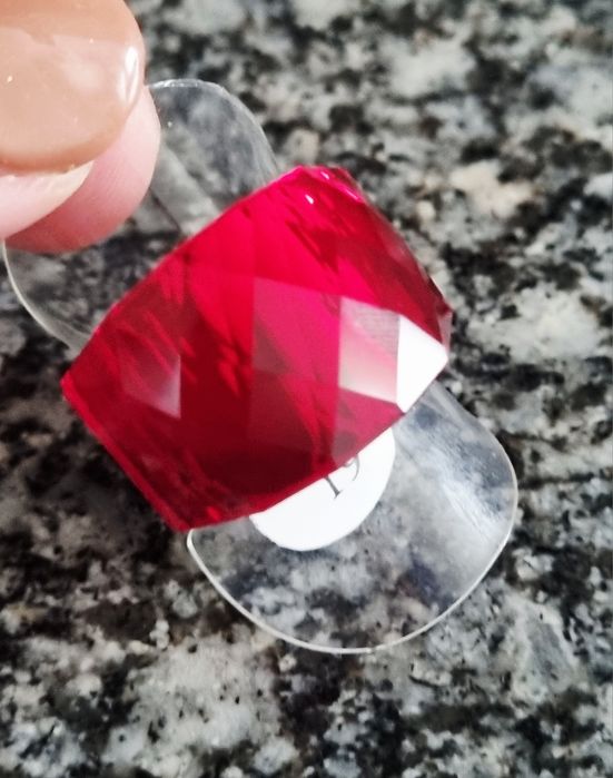 Anel dourado, em aço, com vermelho facetado na parte de cima. T17