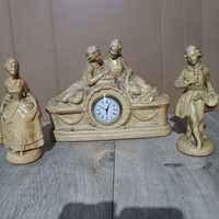 Stary ceramiczny zegar z dwoma figurkami.