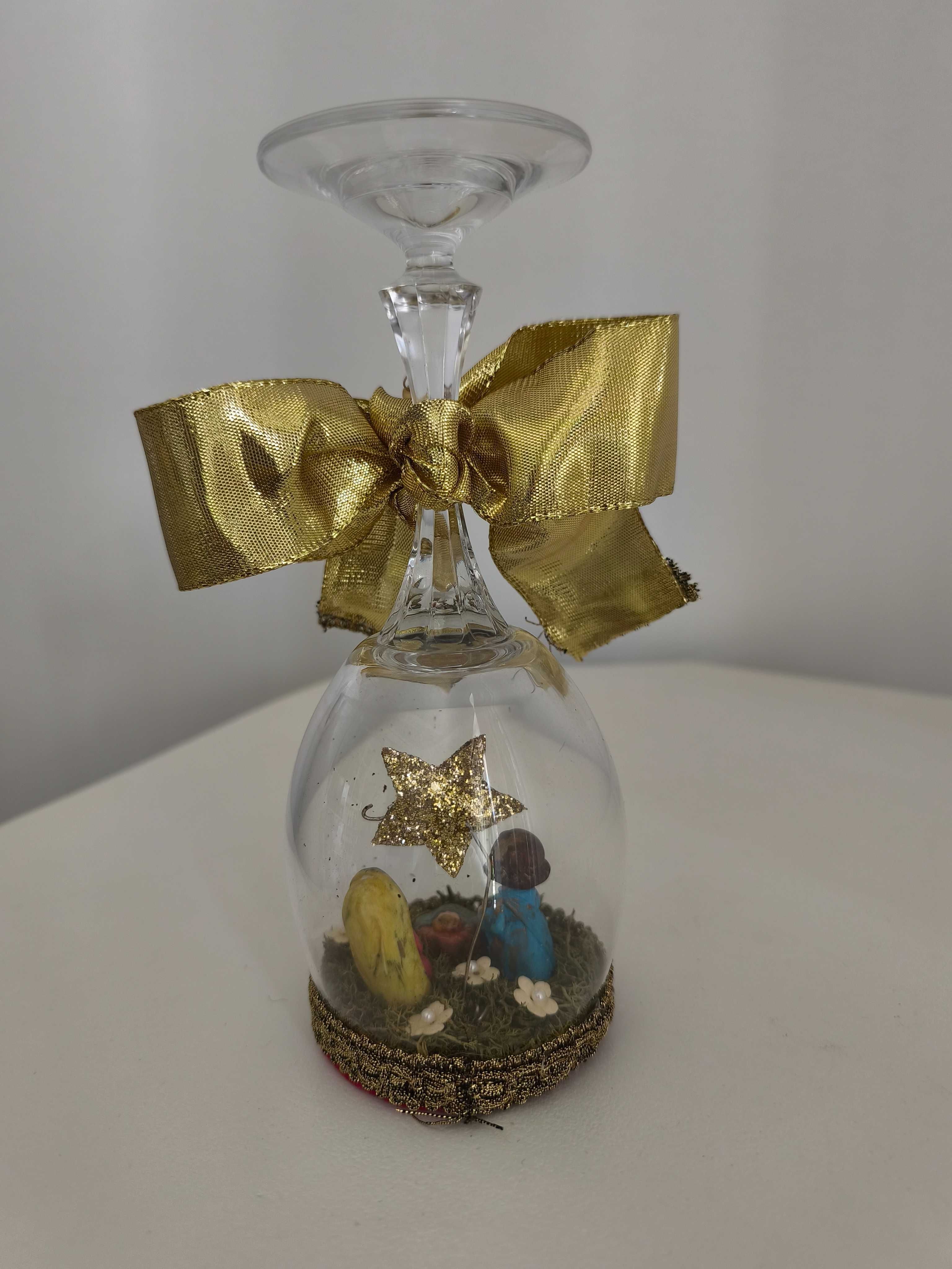 Presépio construído em copo de vidro com laço dourado