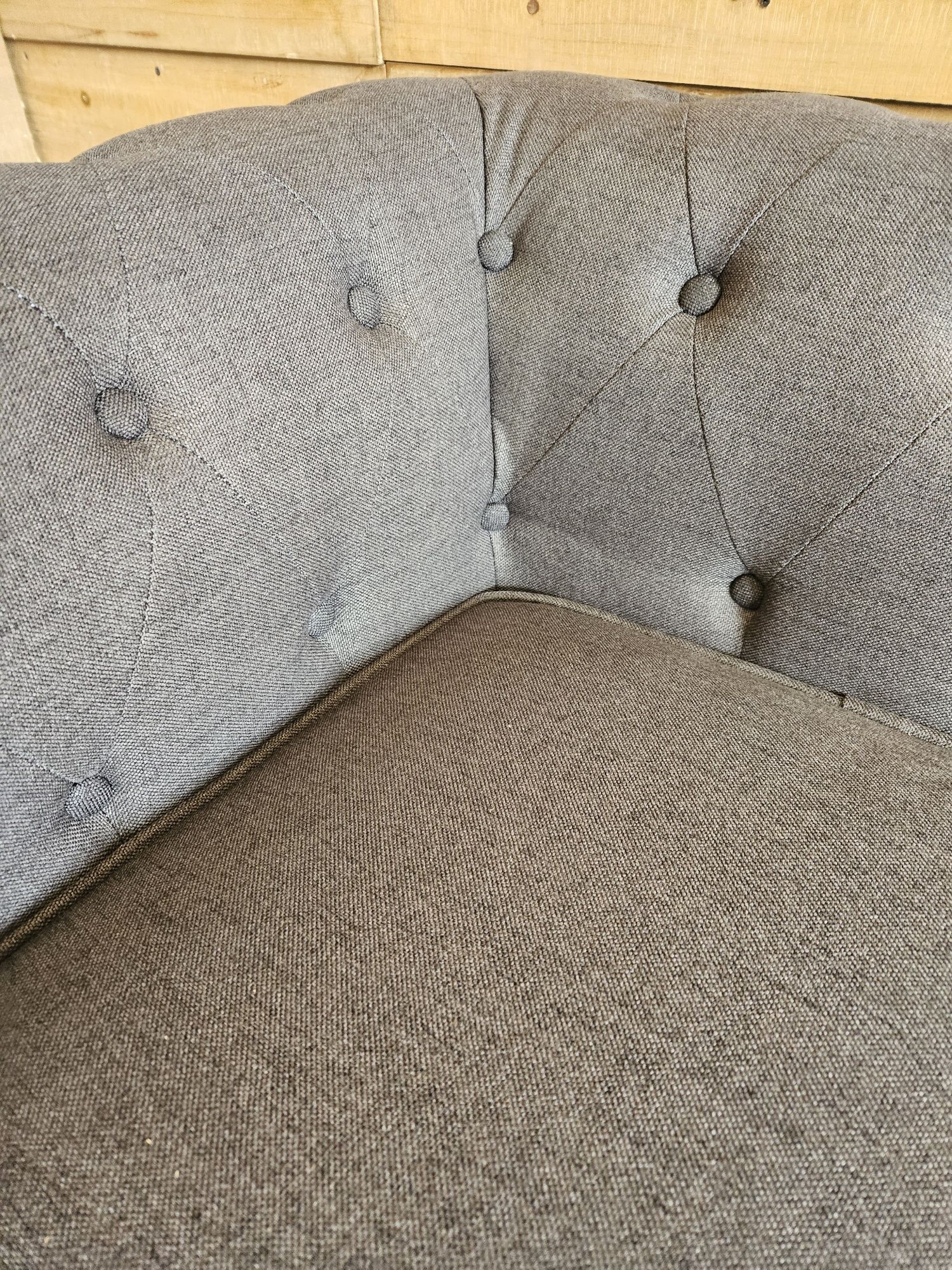 Szara materiałowa sofa Chesterfield