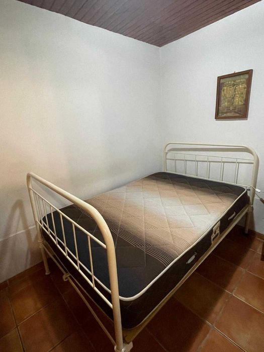 Cama de ferro antiga com colchão e estrado