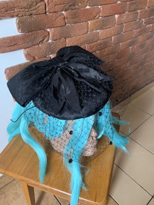 Чорний капелюшок-таблетка з вуаллю та бантом.