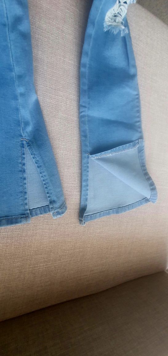 Calça de ganga cintura subida e boca de sino com abertura no fundo