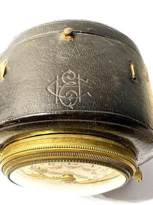 Antigo relógio de viagem com mostrador esmaltado e caixa em couro