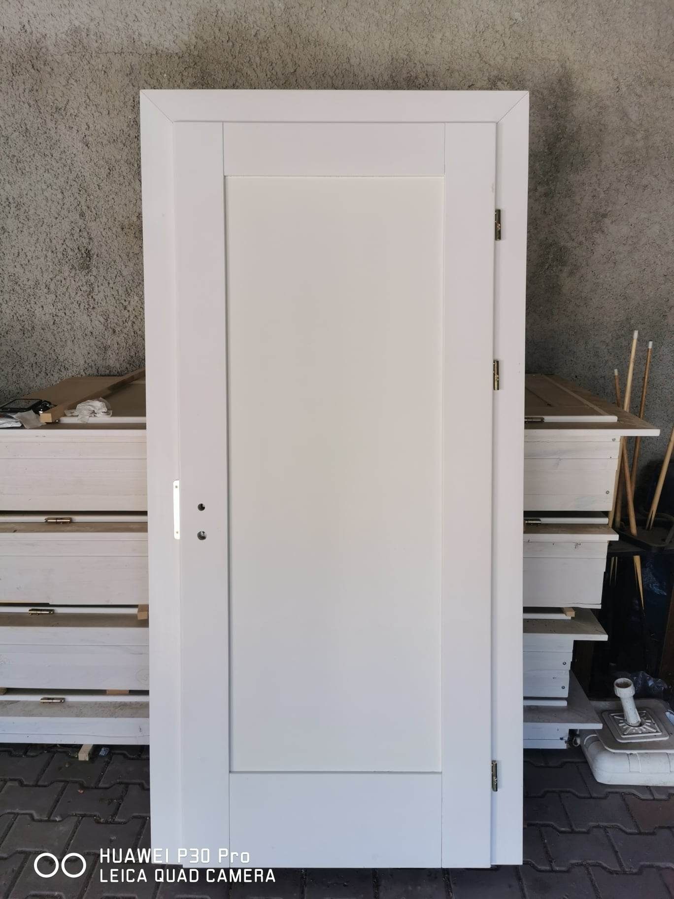 Drzwi białe z ościeżnicą zrobione z drewna jesionowego.