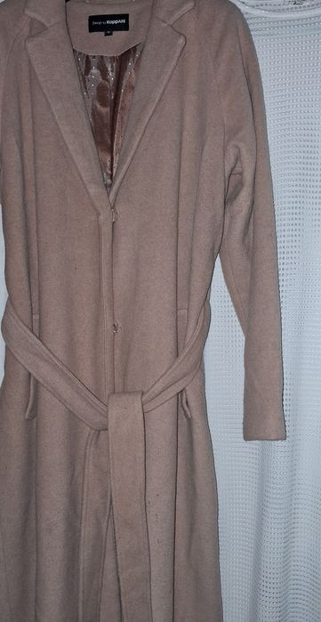 beżowy płaszcz z paskiem marki KappAhl.