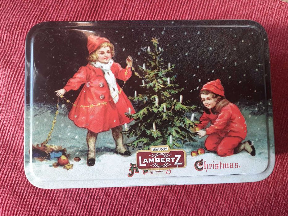 Puszka z motywem dzieci ubierające choinkę.